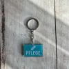 Acryl-Schlüsselanhänger "Pflege" mit Pflaster-Symbol