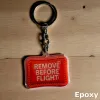 Acryl-Schlüsselanhänger „REMOVE BEFORE FLIGHT“